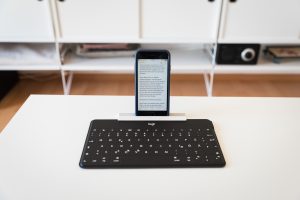 Logitech-Tastatur mit angeklemmten Smartphone-/Tablet-Ständer.